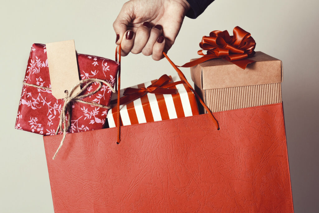 Close-up of a hand holding a bag full of holiday presents